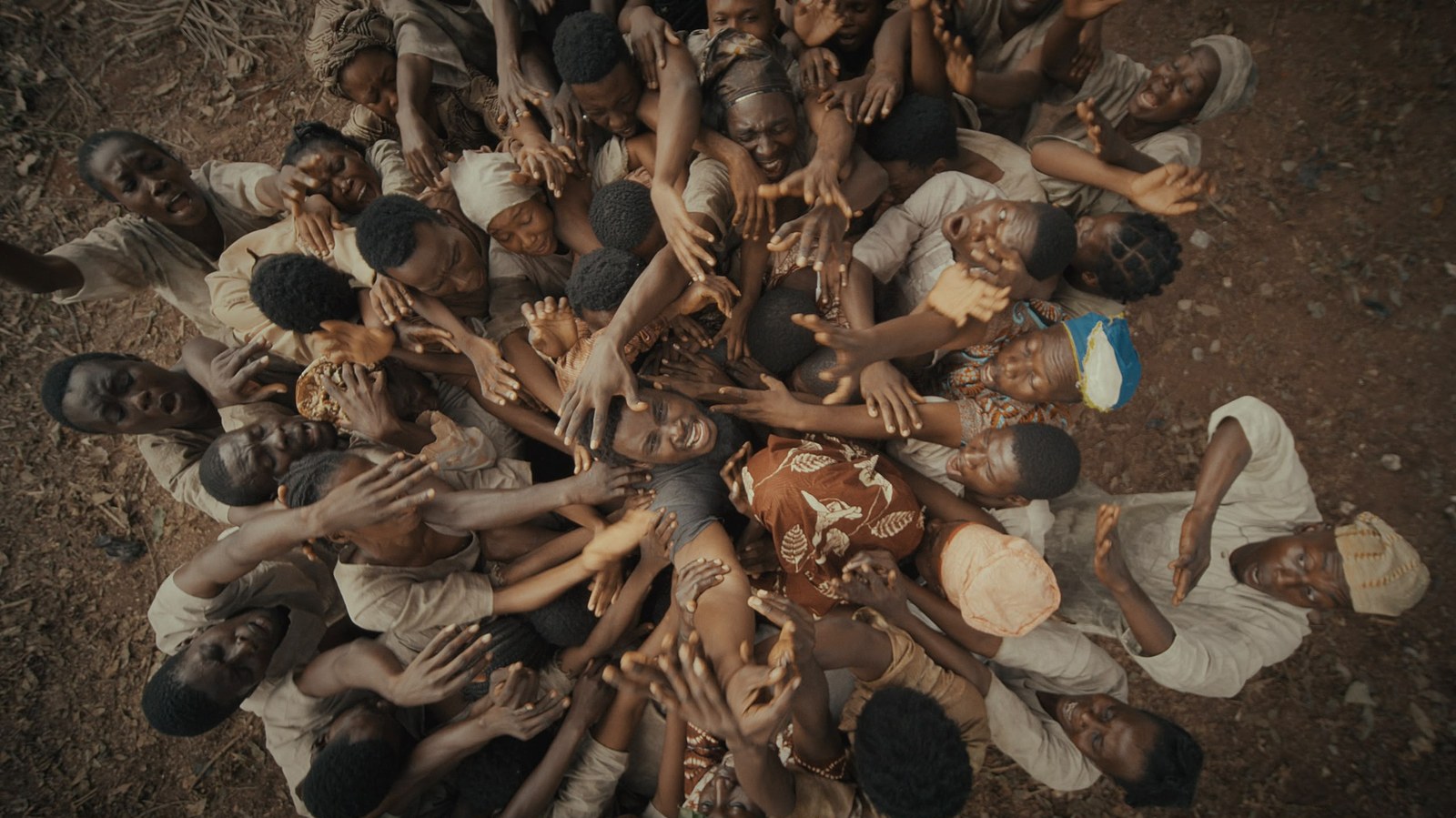 Overhead shot of a crowd reaching their hands upwards, in a still from Agbara Nla: The Return