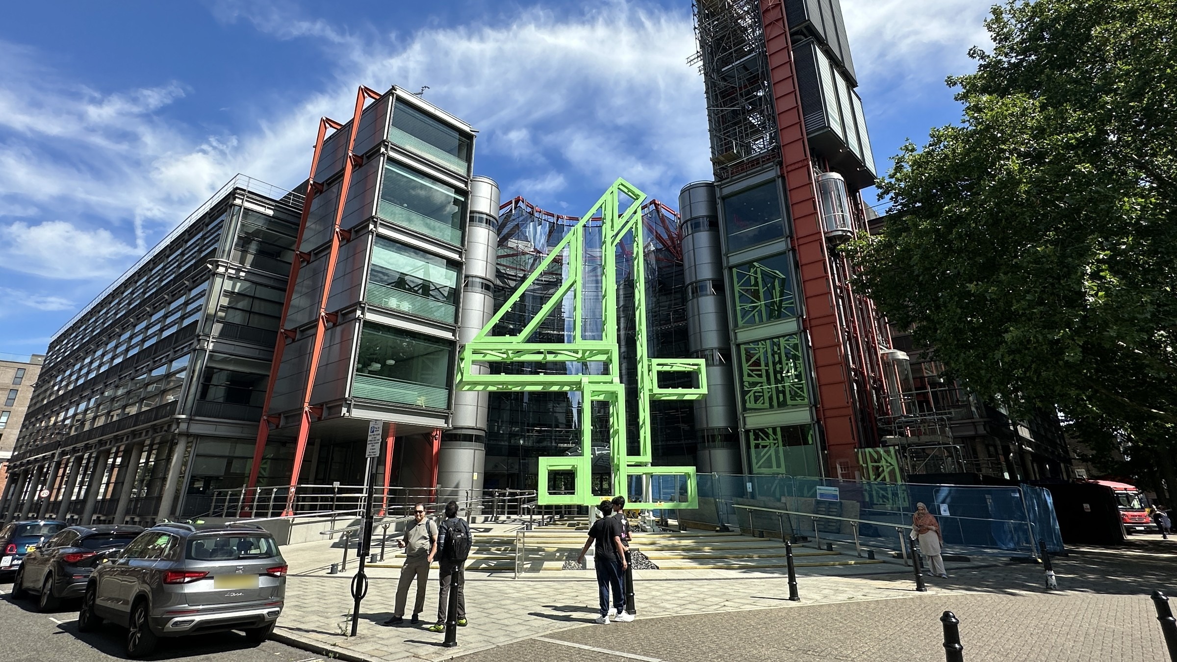 A large green steel sculpture of the Channel 4 number 4 logo in front of the broadcaster’s glass and red-steel headquarters in London