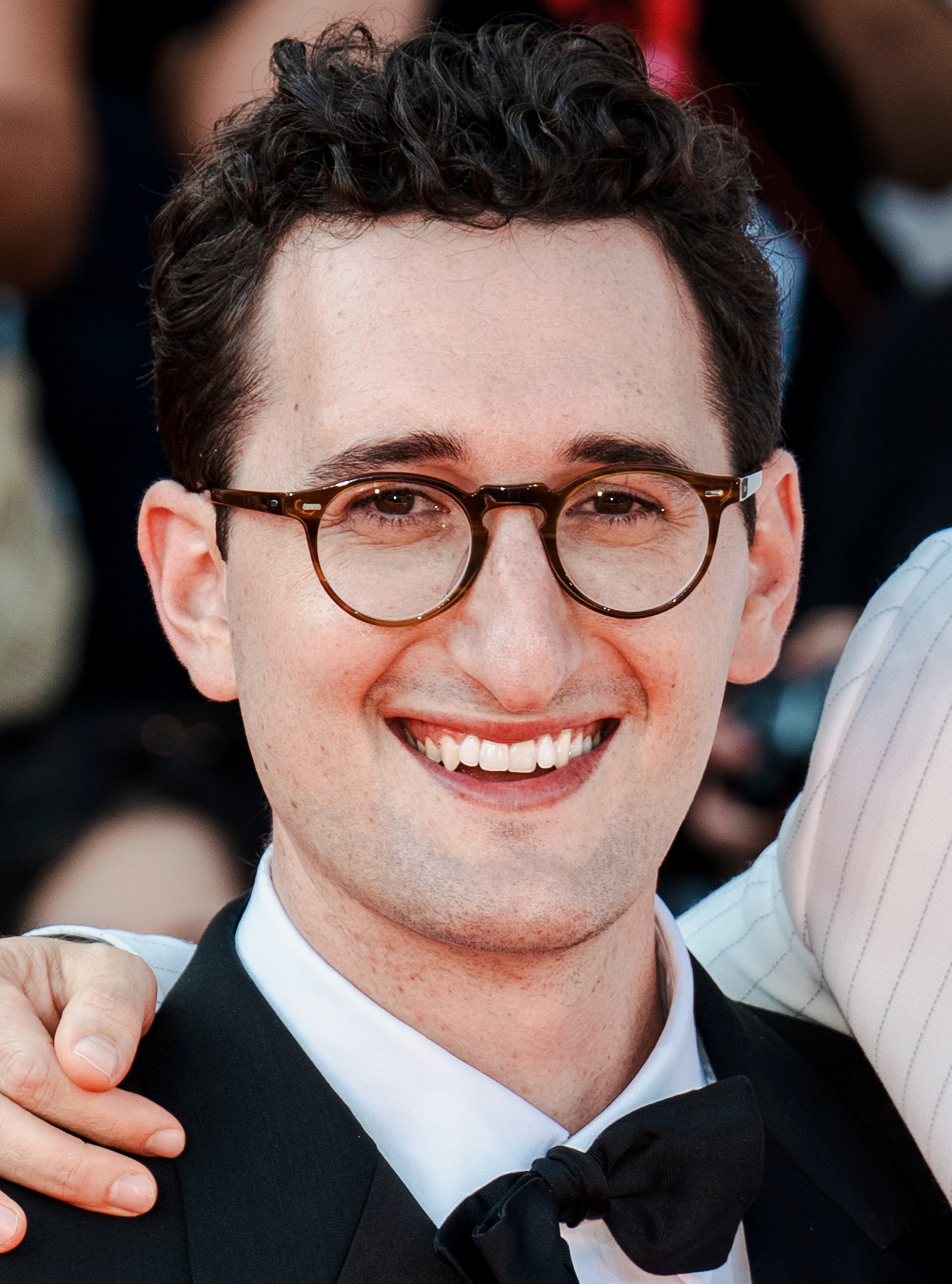 Lance Oppenheim smiling in a tuxedo at a Venice Film Festival premiere
