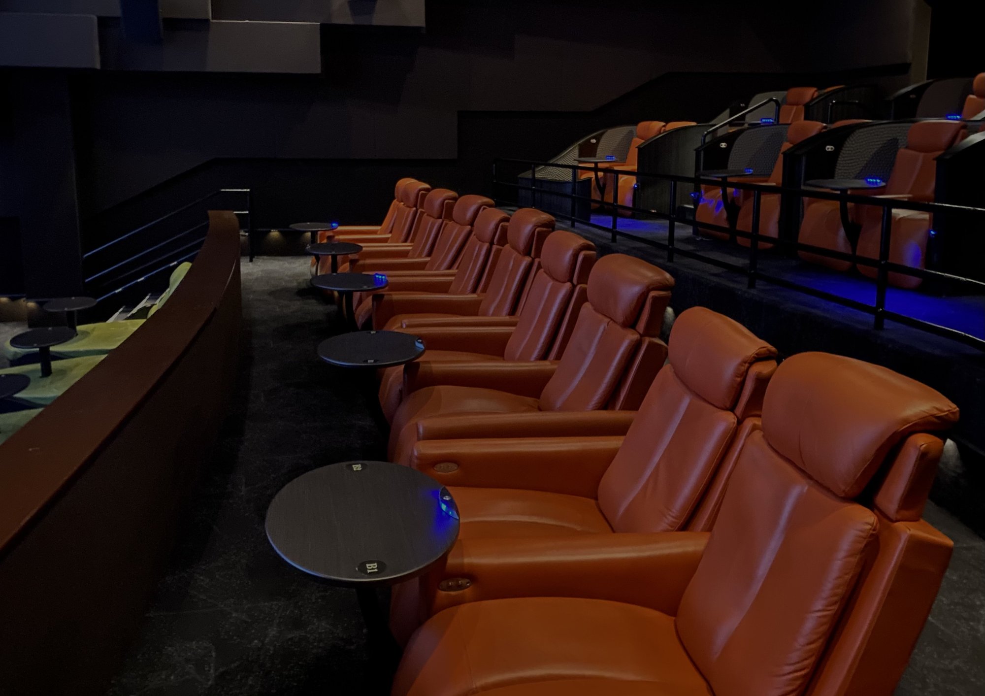 Rows of leather reclining seats with side tables in a US cinema