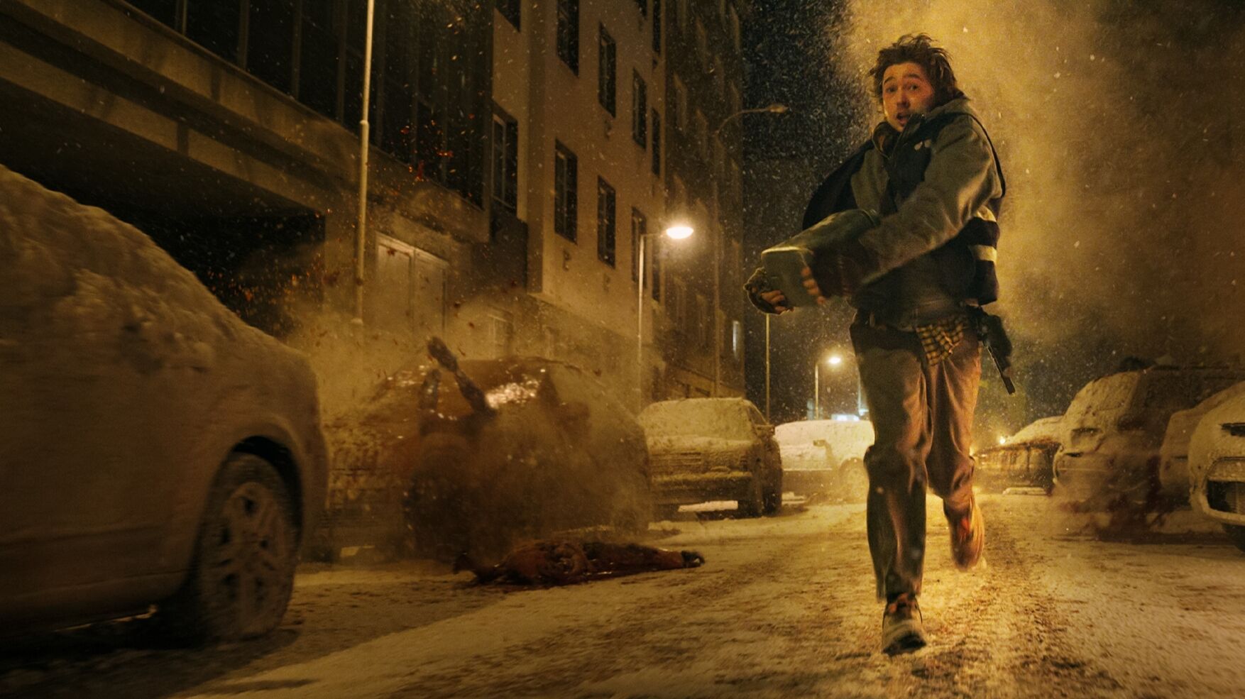 A man running down a snowy night street clutching a medical case, in a still from Resident Evil