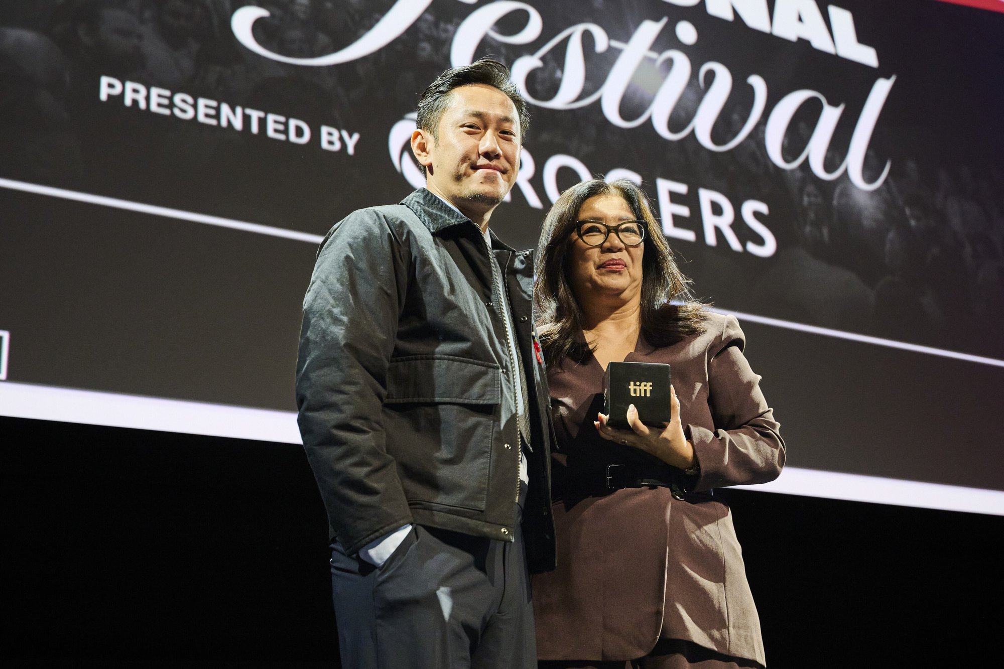 Theja Rio holding the TIFF Platform Award beside Anita Lee