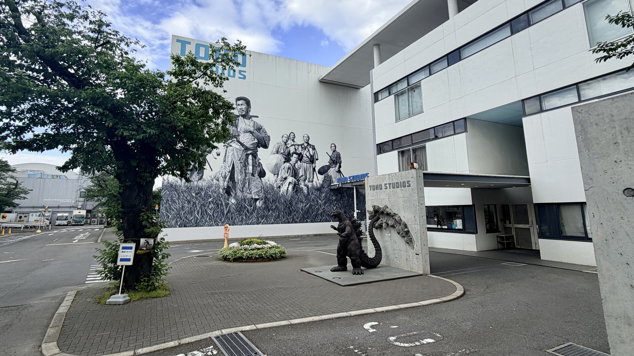 Toho Studios entrance in Tokyo, with a Godzilla statue in front of a large Seven Samurai mural