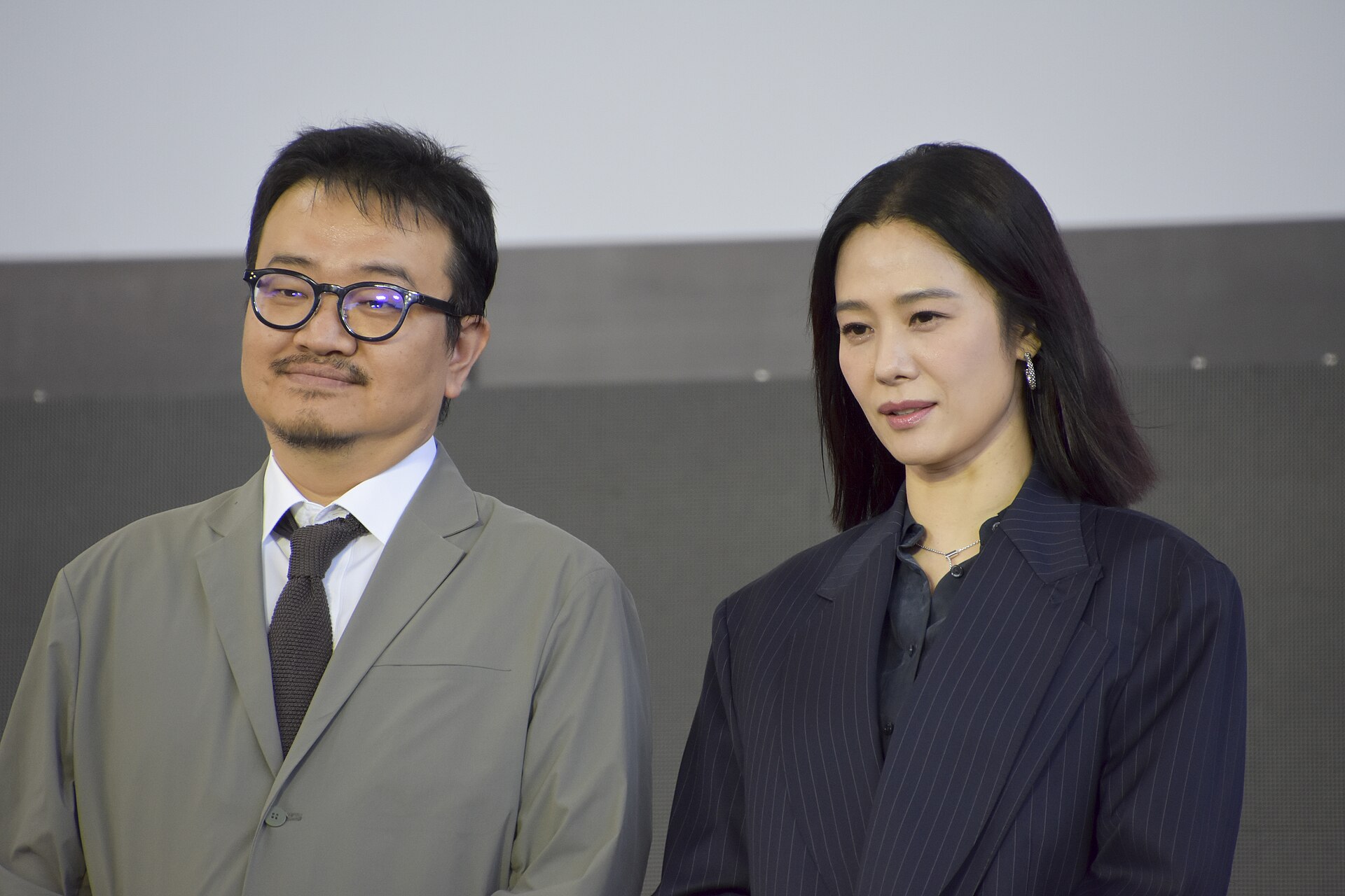 Director Yeon Sang-ho and actor Kim Hyun-joo standing on the outdoor stage at Busan in 2026